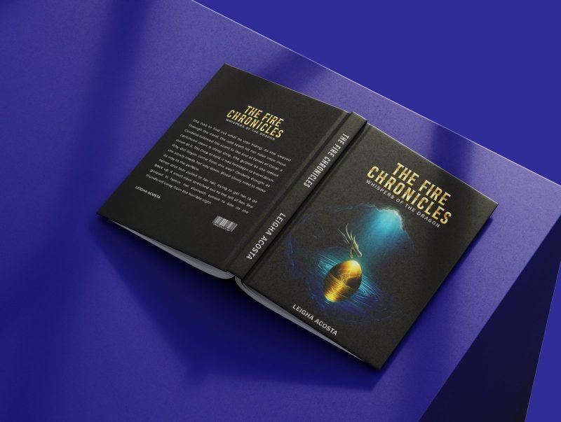 Open hardcover of The Fire Chronicles lying face down on a blue surface